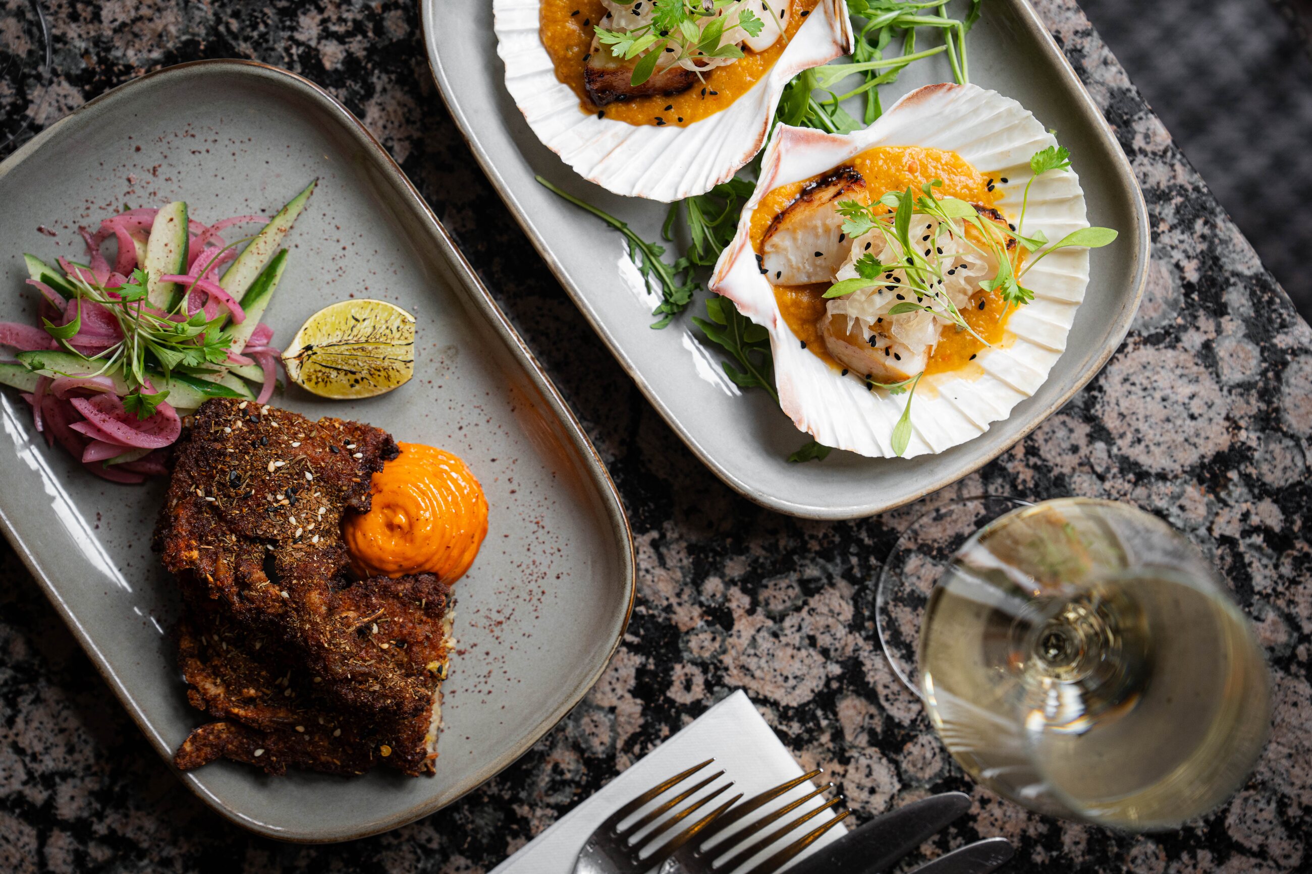 Spice-crusted fish with pickled onion and cucumber, and seared scallops on the shell with carrot purée, at Fishers in the City