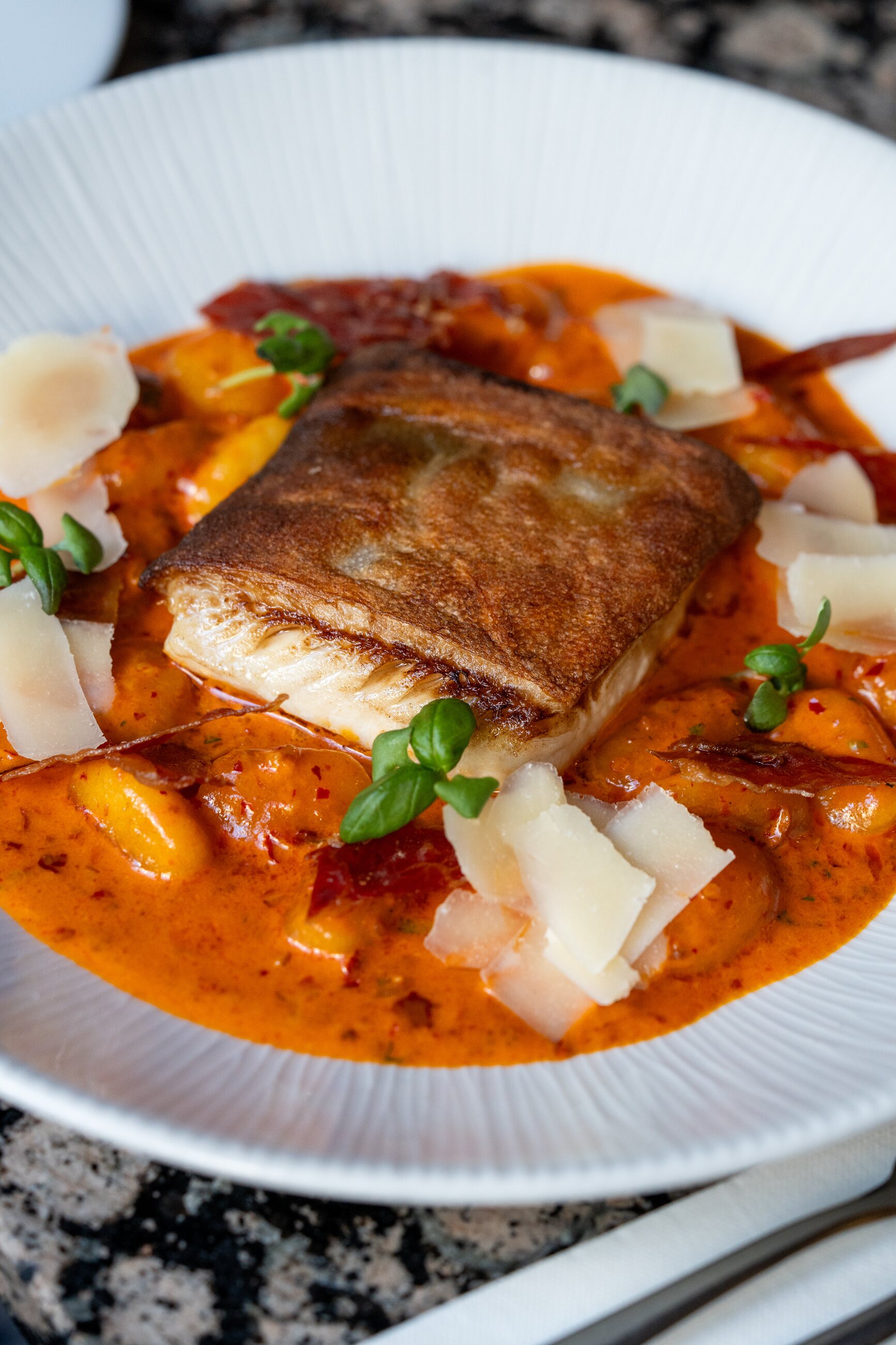 Pan-seared seabream, gnocchi, tomato and pancetta broth